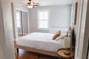 a white bedroom with a bed and a ceiling fan at Near Waterfront, Maryland Renovated Home - Walk to Historic Downtown! in Cambridge