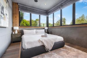 a bedroom with a large bed and windows at Beverly Hillside Haven in Los Angeles