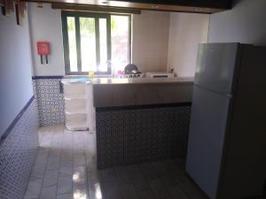 a kitchen with a sink and a refrigerator at Melaya Private Rooms in Faro