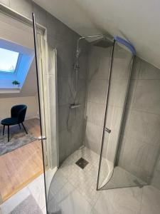 a shower with a glass door in a bathroom at Noah Longstay Liljanstorpsvägen in Västerås