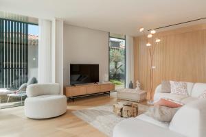 a living room with a white couch and a tv at Savoy Insular I by An Island Apart in Funchal