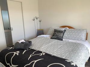 a bedroom with a bed with a black and white comforter at A Beauty on Bligh St Te Anau in Te Anau