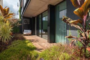 a house with glass doors and a chair on a porch at Savoy Insular I by An Island Apart in Funchal