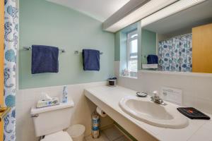 un bagno con lavandino, WC e specchio di House with Hot Tub and Deck - Walk to Seaside Beach! a Seaside Altre 36 foto