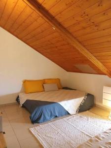 Bett in einem Zimmer mit Holzdecke in der Unterkunft LE GRAND COUDE in Saint-Joseph