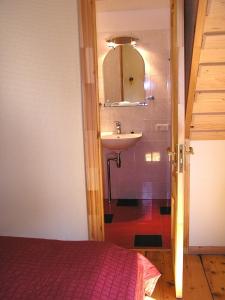 a bathroom with a sink and a mirror and a bed at Majoru Promenāde in Jūrmala