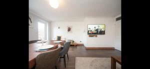 a dining room with a table and chairs in a room at Spacious Chessington home with parking & garden in Chessington