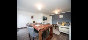 een woonkamer met een tafel en een bank bij Spacious Chessington home with parking & garden in Chessington