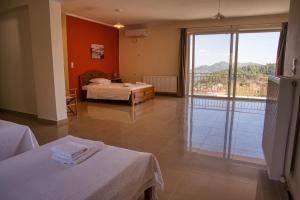 een hotelkamer met twee bedden en een groot raam bij Petronas Villa in Kariá +40 foto's