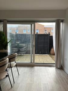 a living room with a sliding glass door to a patio at Stylish Meets Luxury! 2 Bed 2 Bath Family Home in Dagenham
