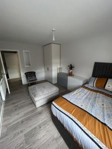 sypialnia z łóżkiem i kanapą w obiekcie Stylish Meets Luxury! 2 Bed 2 Bath Family Home w mieście Dagenham