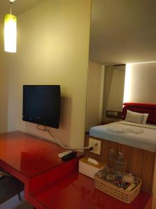 Un dormitorio con una cama y un televisor en la pared. en เพอร์เฟลคเพลช (Perfect Place Hotel), en Ban Khlong Phruan 9 fotos más