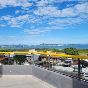 uma vista a partir da varanda de um edifício com um corrimão amarelo em Ape frente praia Ponta das Canas/3min Canasvieiras em Florianópolis