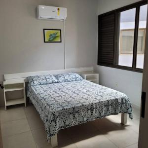 um quarto com uma cama e uma janela em Ape frente praia Ponta das Canas/3min Canasvieiras em Florianópolis