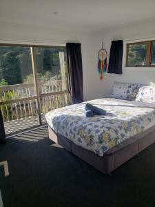a bedroom with a large bed and a balcony at Paihia Retreat in Paihia
