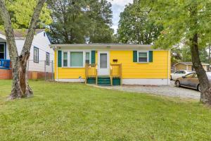 een geel huis met een auto in een tuin bij Cozy Greensboro Vacation Rental with Deck and Fire Pit in Greensboro