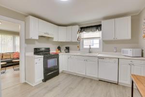 een keuken met witte kasten en een fornuis met oven bij Cozy Greensboro Vacation Rental with Deck and Fire Pit in Greensboro