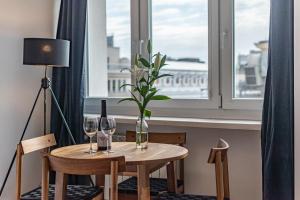 a table with wine glasses and a vase with a plant at Apartament Jasna by Your Freedom in Warsaw