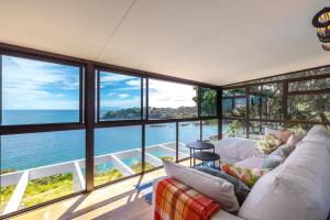 a living room with a view of the ocean at Clifftop Sanctuary in Oneroa
