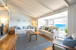 uma sala de estar com dois sofás e vista para o oceano em Clifftop Sanctuary em Oneroa