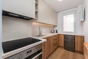 una cocina con fregadero y estufa horno superior en Apartament Jasna by Your Freedom, en Varsovia