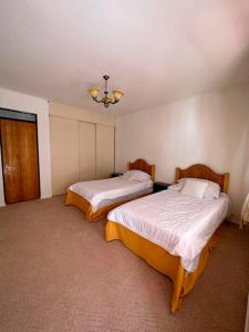 a bedroom with two beds and a chandelier at Hotel Termas del Salitre in Mamiña