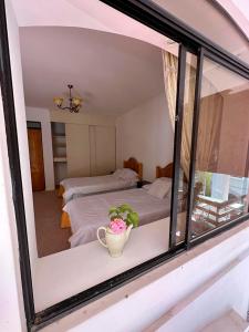 a reflection of a bedroom with a bed and a window at Hotel Termas del Salitre in Mamiña