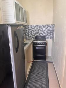 a small kitchen with a stove and a refrigerator at APARTAMENTO ZONA COLONIAL R in Santo Domingo