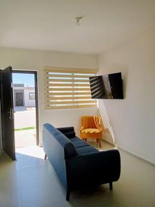 a living room with a blue couch and a television at Casa Valtierra, La Paz in La Paz