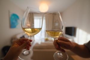 two people holding up glasses of white wine at Casa Lura at Gjiri i Lalzit, San Pietro Beach in Durrës +45 photos