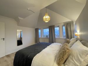 a bedroom with a large bed and a chandelier at aday - Frederikshavn Penthouse in Frederikshavn