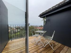 a balcony with a table and chairs on a deck at aday - Frederikshavn Penthouse in Frederikshavn