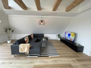 a living room with a couch and a tv at aday - Frederikshavn Penthouse in Frederikshavn