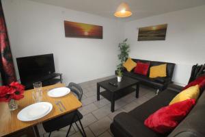 a living room with a couch and a table at Dinnington House in Dinnington