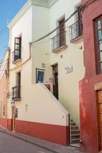 a building with stairs and balconies on a street at Hostal Encounter Guanajuato in Guanajuato
