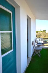 une terrasse couverte avec une porte bleue et une chaise dans l'établissement Mola-Mola Sagres, à Sagres