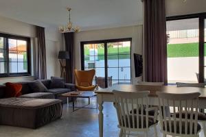Una sala de estar con un sofá, una mesa y sillas. en Dalyan Villa Saki, en Dalyan