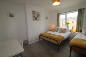 a bedroom with two beds and a window at Dinnington House in Dinnington