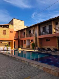 a hotel with a swimming pool in front of a building at Pousada Missare in Canoa Quebrada