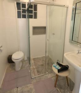 a bathroom with a shower and a toilet and a sink at Casa no Centro de Concórdia - SC in Concordia