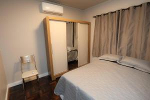 a bedroom with a large bed and a window at Casa no Centro de Concórdia - SC in Concordia