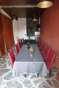 a dining room with a table and red chairs at Aladin Comfort Country House in Campinho
