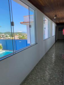 a room with windows and a view of a pool at Pousada Natalli in Cabo Frio