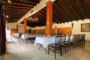 un salón de banquetes con mesas blancas y sillas en Hotel Pie de la Sierra, en Uruapan del Progreso
