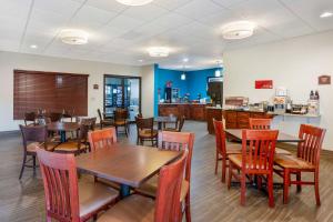 a restaurant with tables and chairs and a kitchen at Best Western Plus Springfield Airport Inn in Springfield