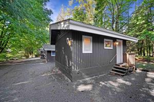 Ein schwarzes, kleines Haus im Wald in der Unterkunft Sunwolf Riverside Cabins in Brackendale