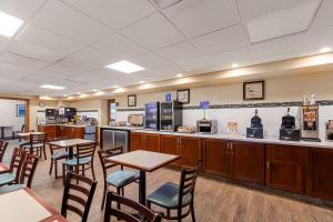 a restaurant with tables and chairs and a kitchen at Best Western Bridgeview Hotel in Superior