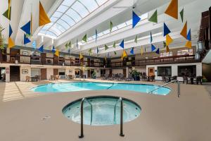 a large swimming pool in a building with flags at Best Western Bridgeview Hotel in Superior