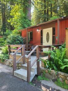 een hut met een trap en een huis met bomen bij Fern River Resort in Felton