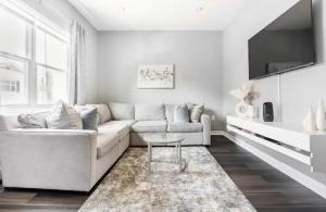 uma sala de estar branca com um sofá e uma mesa em Cozy House 20 min to NYC up to 8 People em Fairview